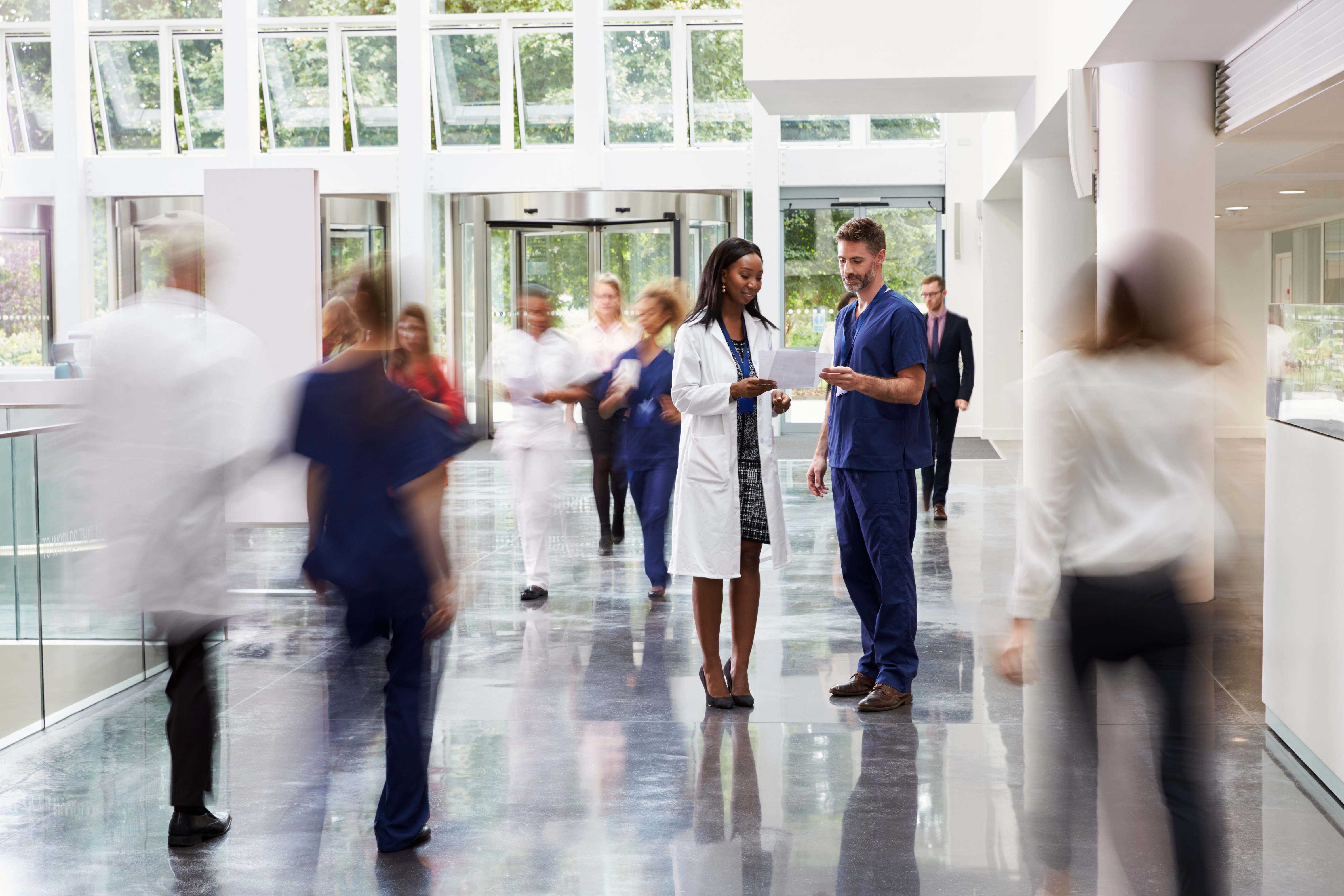 Hospital interior with medical professionals and people walking