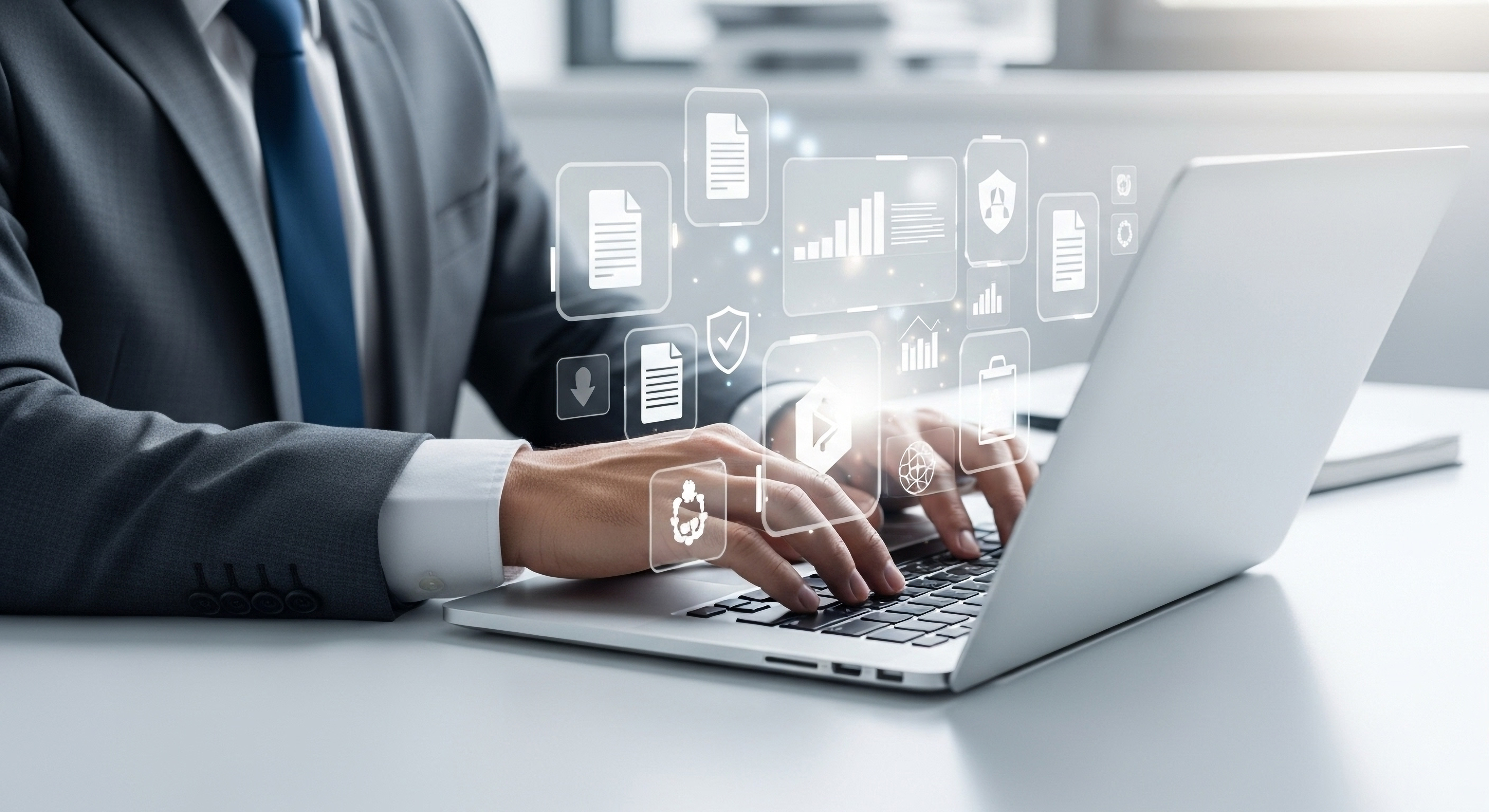 Business man at laptop with charts and digital documents