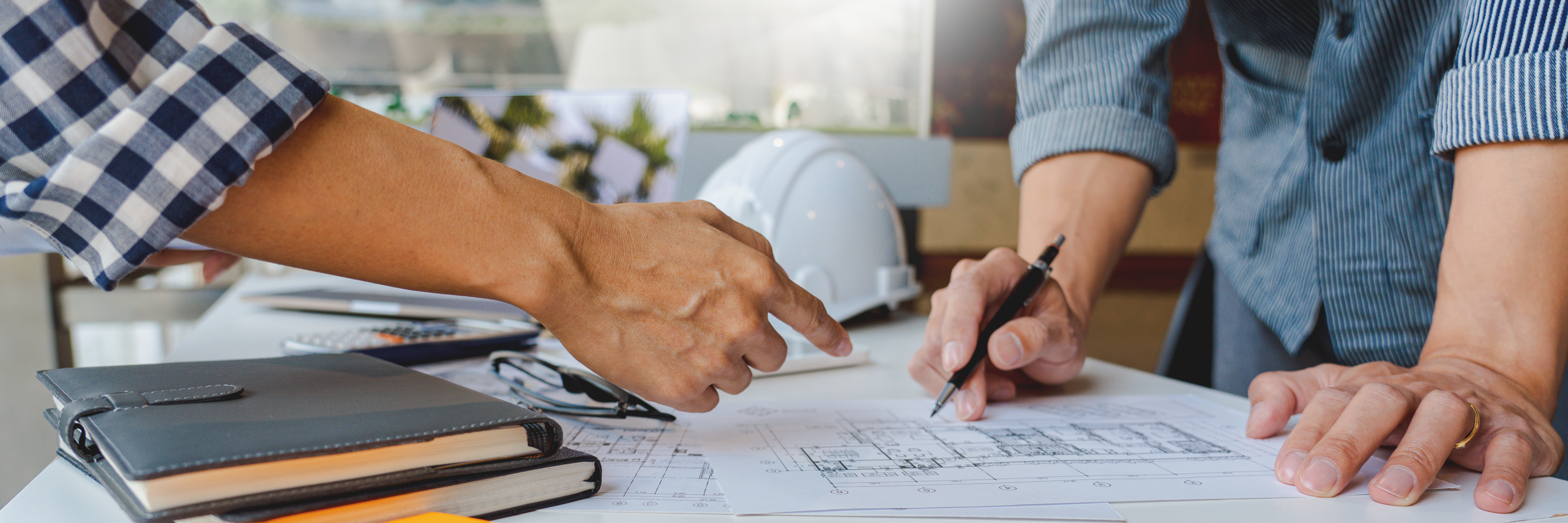 Employee hands pointing at blueprints
