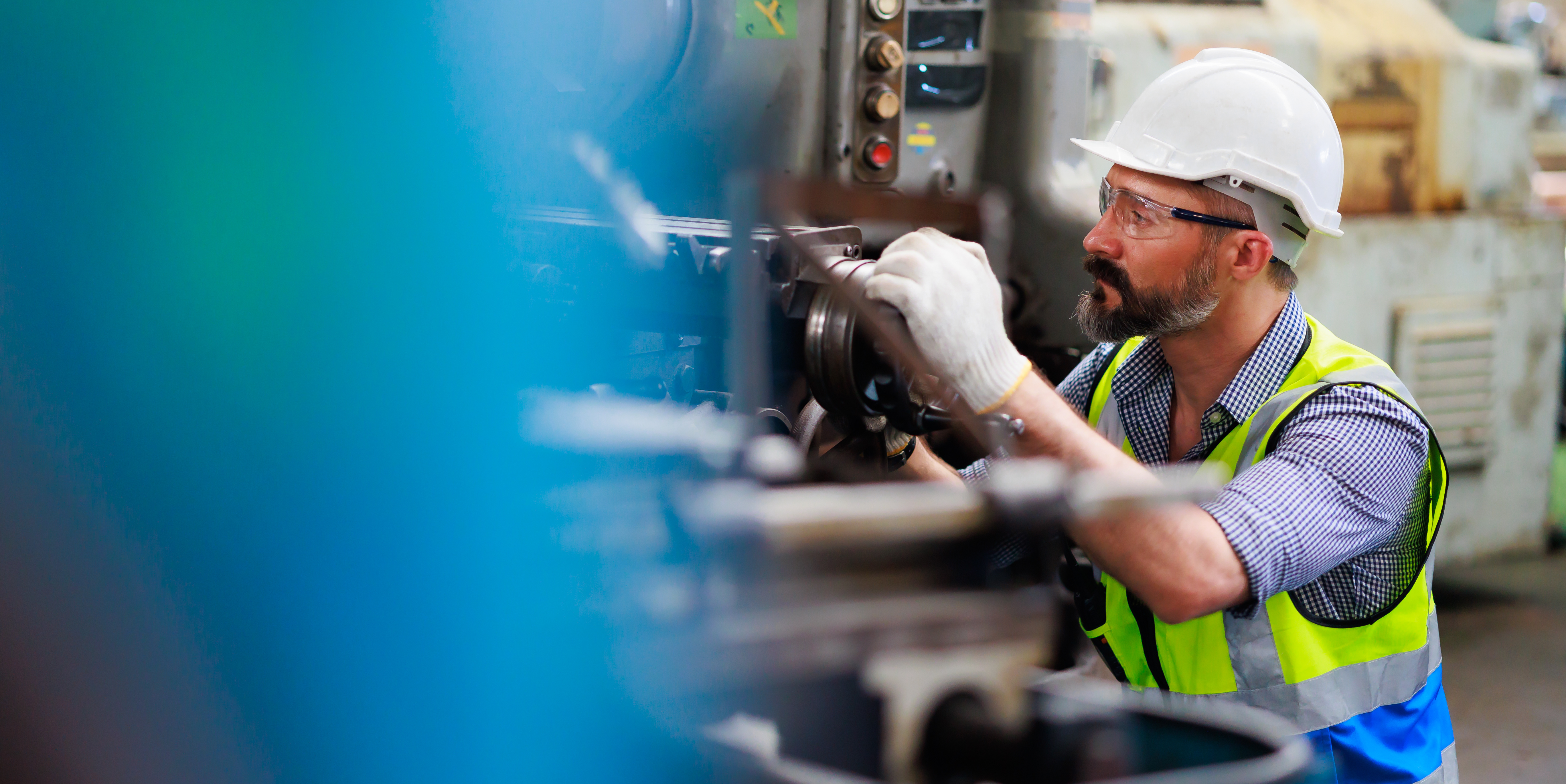 Worker with hard hat checking machinery